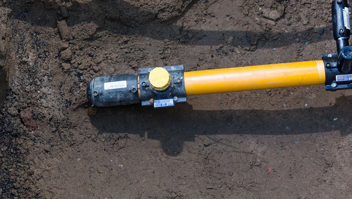 Gasnetz-Hausanschluss in einer offenen Baugrube von oben betrachtet.